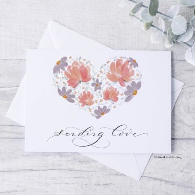 Sending-Love-Card-Staged Notecard with watercolor heart filled with peonies, daisies and leaves. Text in calligraphy below reading "sending love"