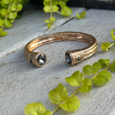Gold cuff bangle with a dark gemstone